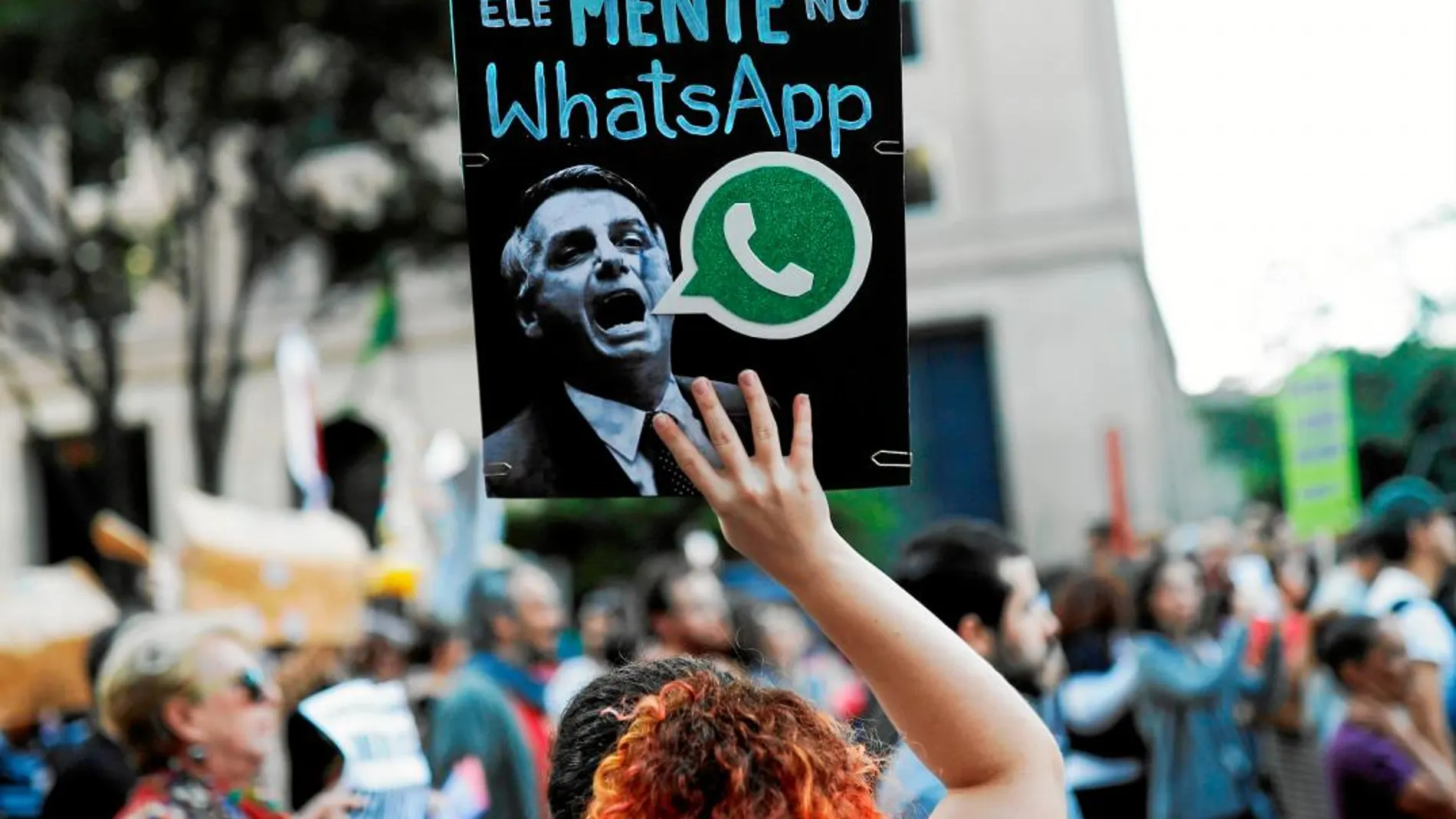 Una mujer protesta contra las mentiras del ultra en internet / Foto: Ap