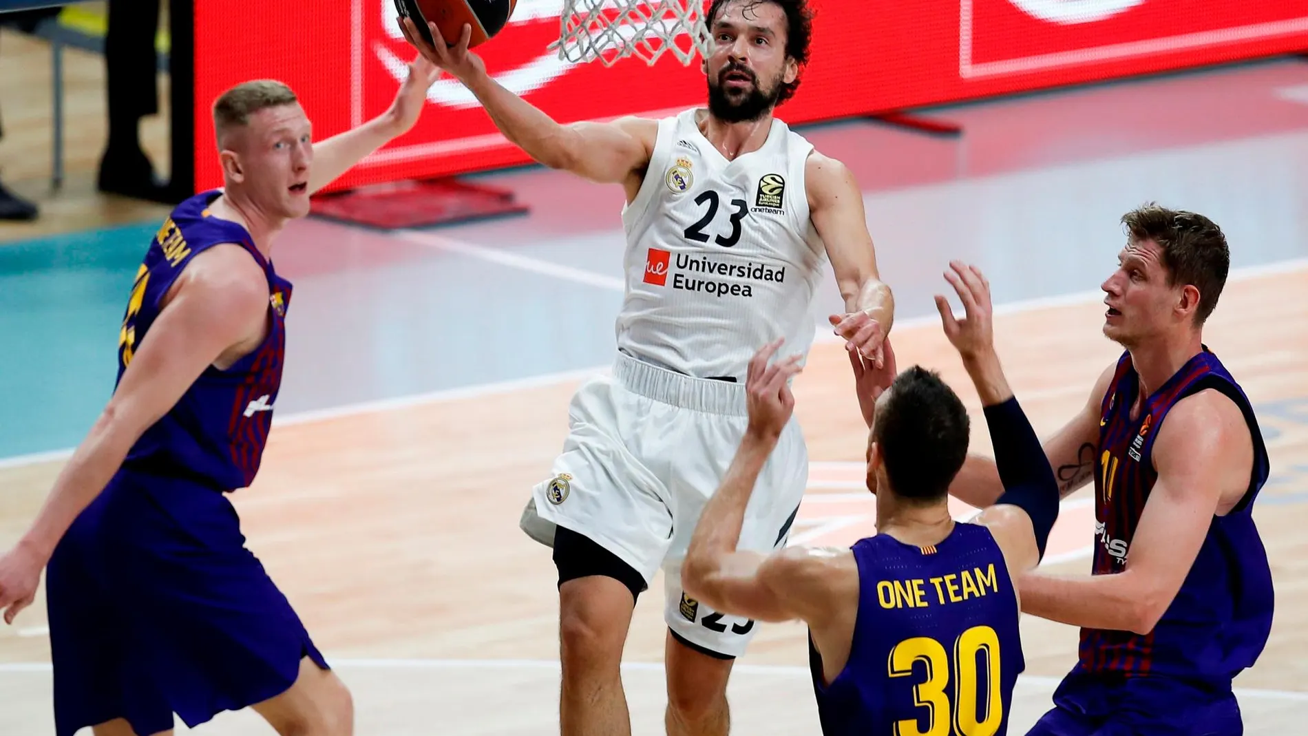 El escolta del Real Madrid Sergio Llull (2-i) entra a canasta rodeado de jugadores del Barcelona Lassa / Efe