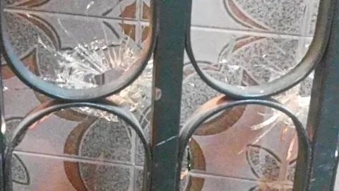 La puerta del portal tenía, al menos, cuatro balazos que rompieron el cristal. Una de las balas quedó incrustada en los barrotes de hierro