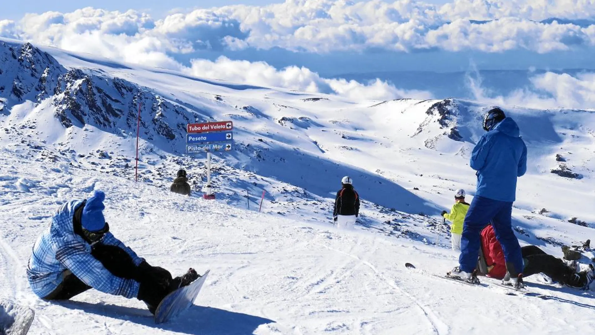 Varios practicantes de snowboard se preparan en una de las pistas de la estación de esquí granadina de Sierra Nevada