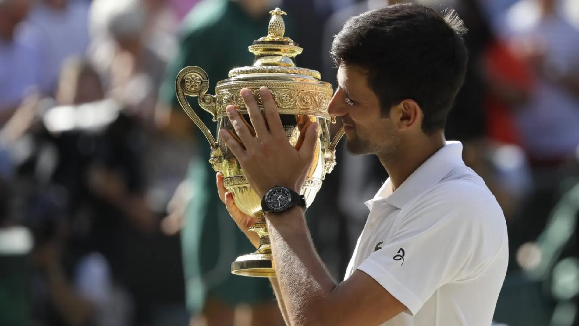 Novak Djokovic sujeta el trofeo que le consagra como ganador de Wimbledon. (AP Photo/Kirsty Wigglesworth)