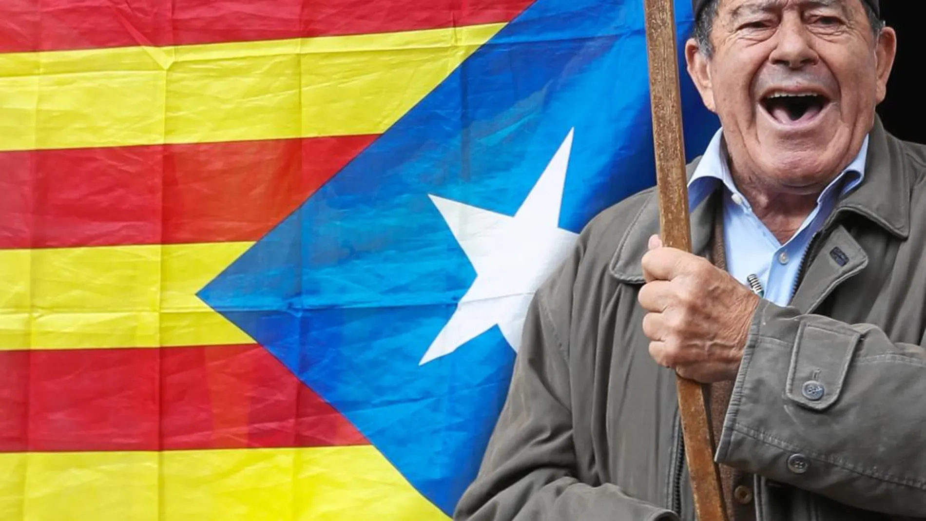 Un hombre enarbola una bandera «estelada» y usa una barretina, tocado considerado como un símbolo catalanista