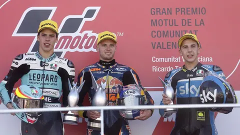 El surafricano Brad Binder (c), campeón del Mundo de Moto3, en el podio junto al español Joan Mir (i), segundo, y el italiano Andrea Migno (d).