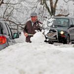 Un vecino del pueblo de Pajares trata de sacar su coche tras la nevada de esta mañana / Foto. Efe