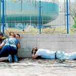 Israelíes se cubren tras escuchar el ruido de las sirenas que avisan del lanzamiento de cohetes desde la franja de Gaza / Reuters
