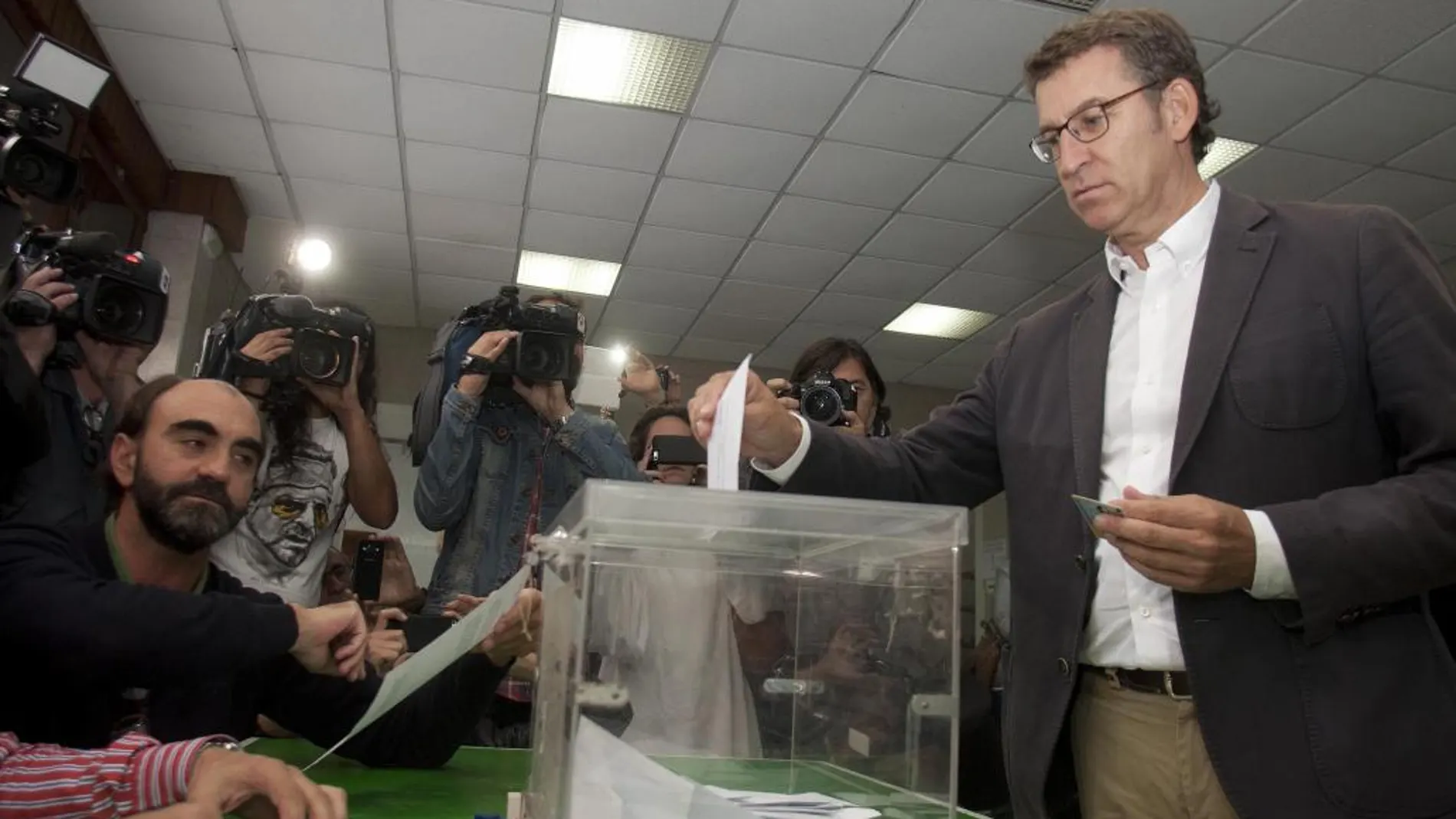 El candidato del PP a la Presidencia de la Xunta, Alberto Núñez Feijóo (d), deposita su voto.