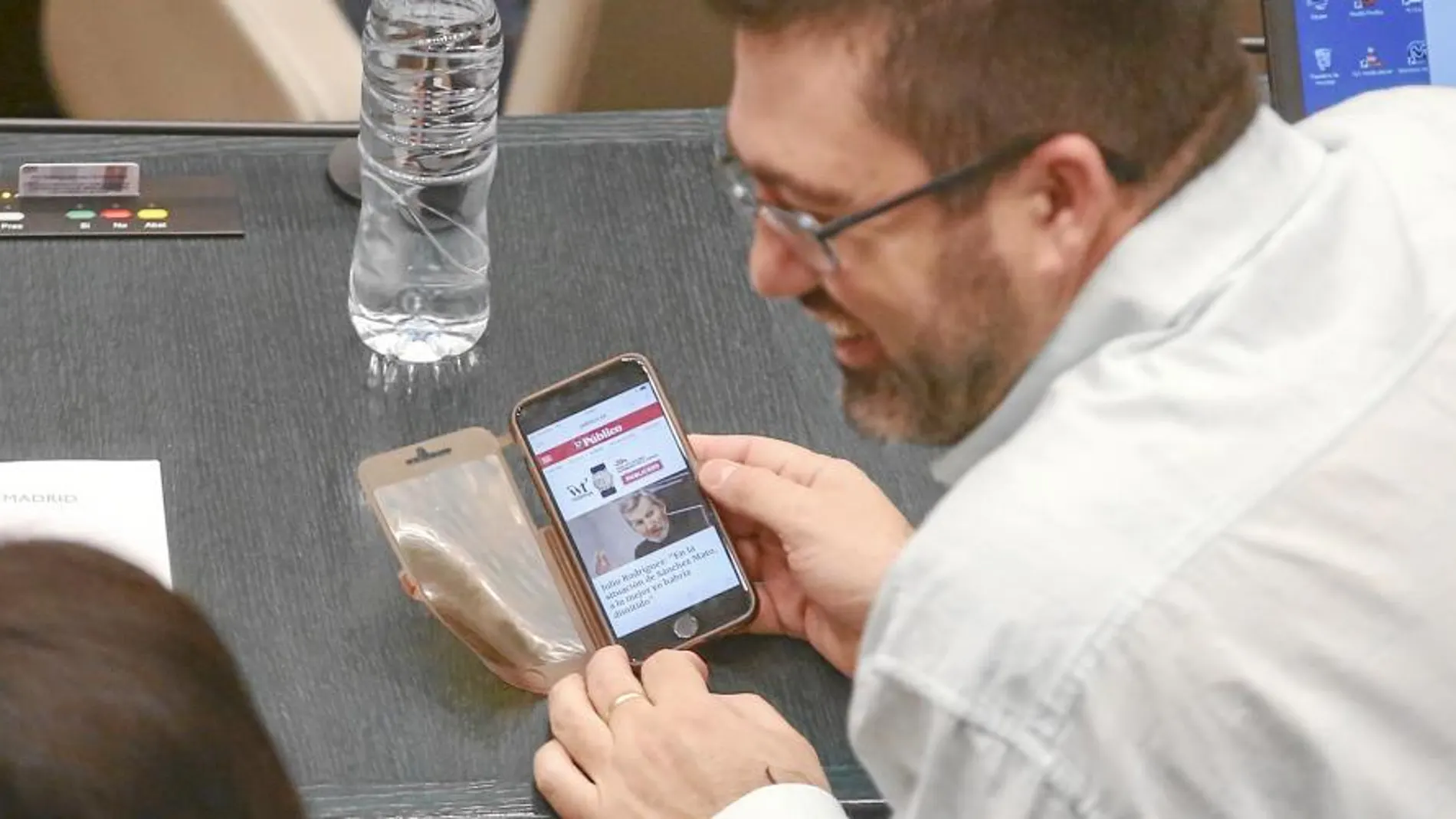 En la imagen muestra entre risas a los ediles de Ganemos Pablo Carmona y Rommy Arce una entrevista del secretario general de Podemos Madrid, Julio Rodríguez, en laque asegura: «En la situación de Sánchez Mato a lo mejor yo habría dimitido».