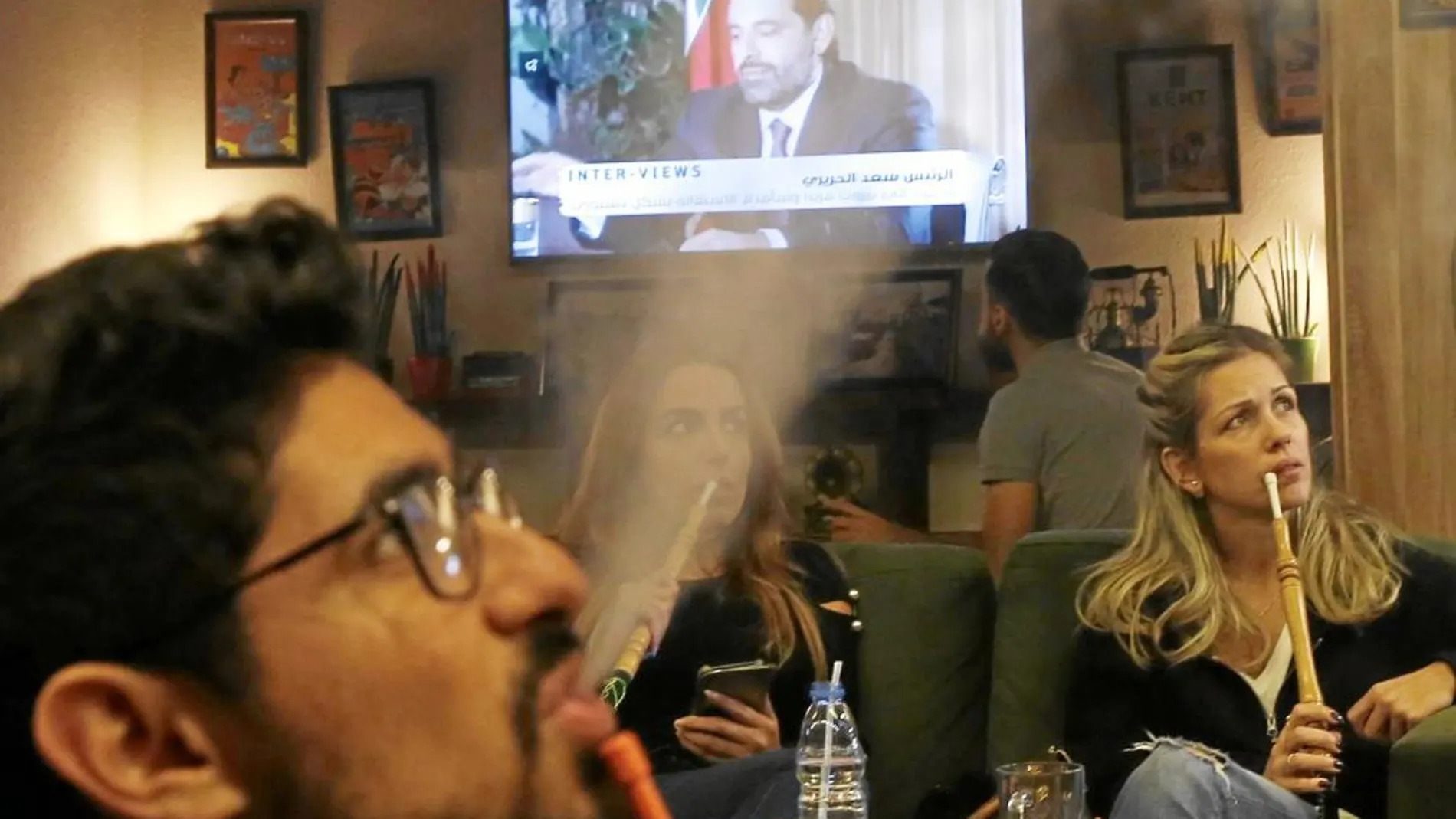 Libaneses escuchan la entrevista al primer ministro Hariri en un café de Beirut