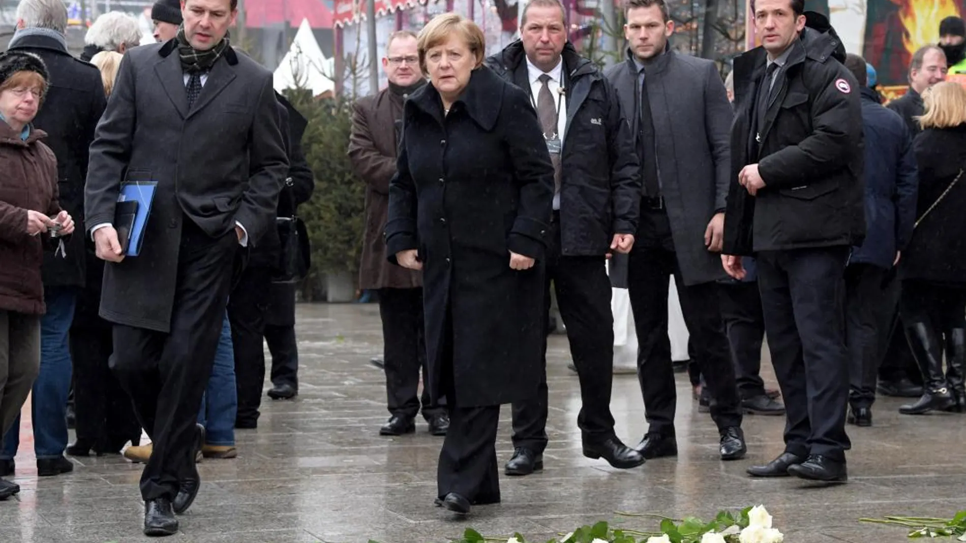 La canciller alemana, Angela Merkel (c), asiste a una ceremonia de conmemoración del primer aniversario del atentado islamista en el que murieron doce personas en Berlín