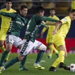 El delantero del Villarreal Santos Borre (d) pelea un balón con el defensa del CD Toledo Daniel Pérez (c) y el centrocampista Israel Castro durante el partido