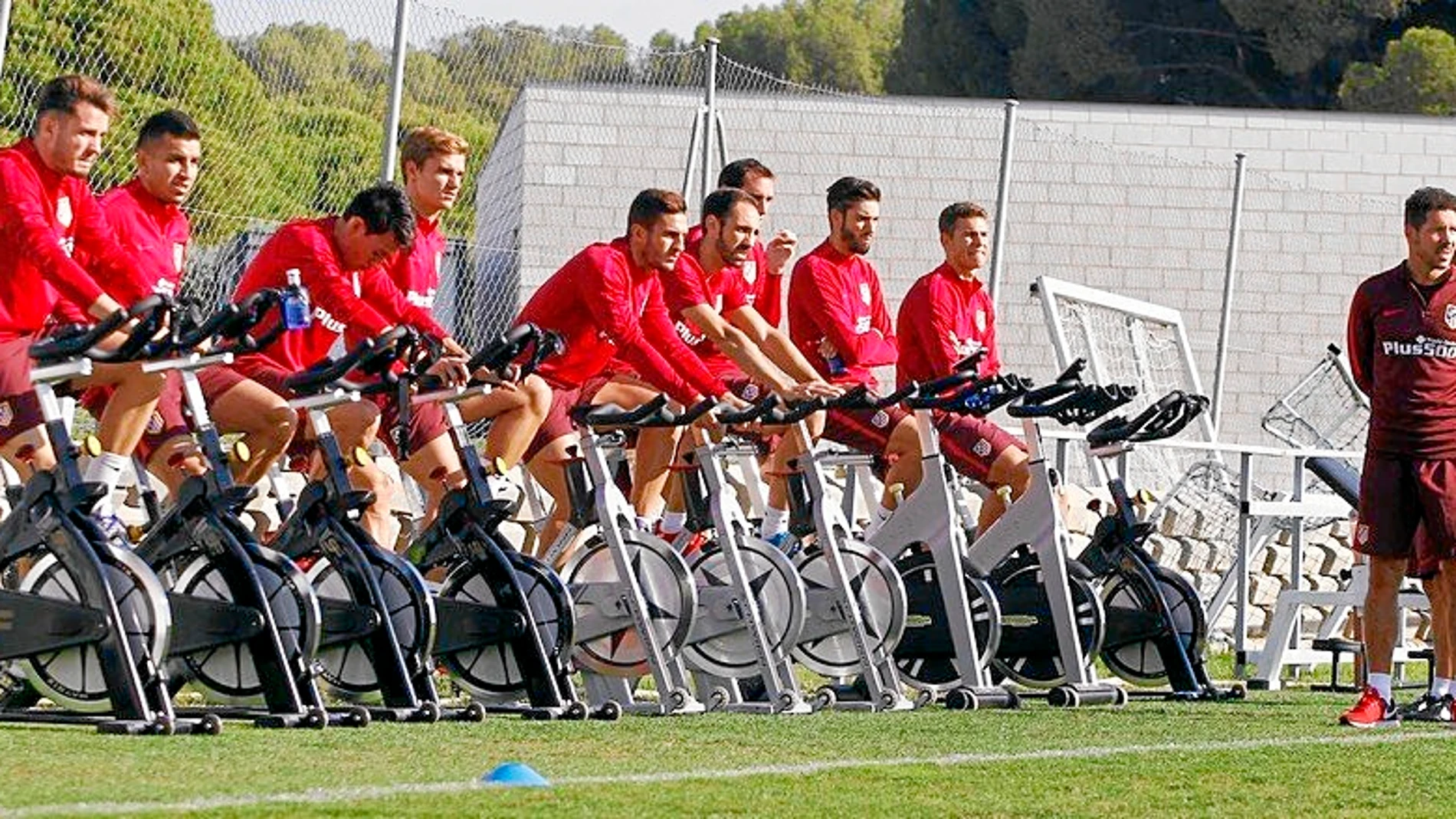 Los jugadores del Atlético trabajan sobre la bicicleta en el entrenamiento de ayer