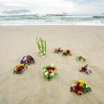 Juan, abuelo del niño fallecido, dejó unas flores en la playa de Getares, donde murió su nieto hace una semana