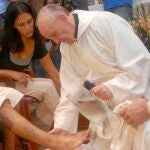 El que fuera cardenal Bergoglio, en Villamiseria (Buenos Aires), durante el lavatorio de los pies con unos jóvenes