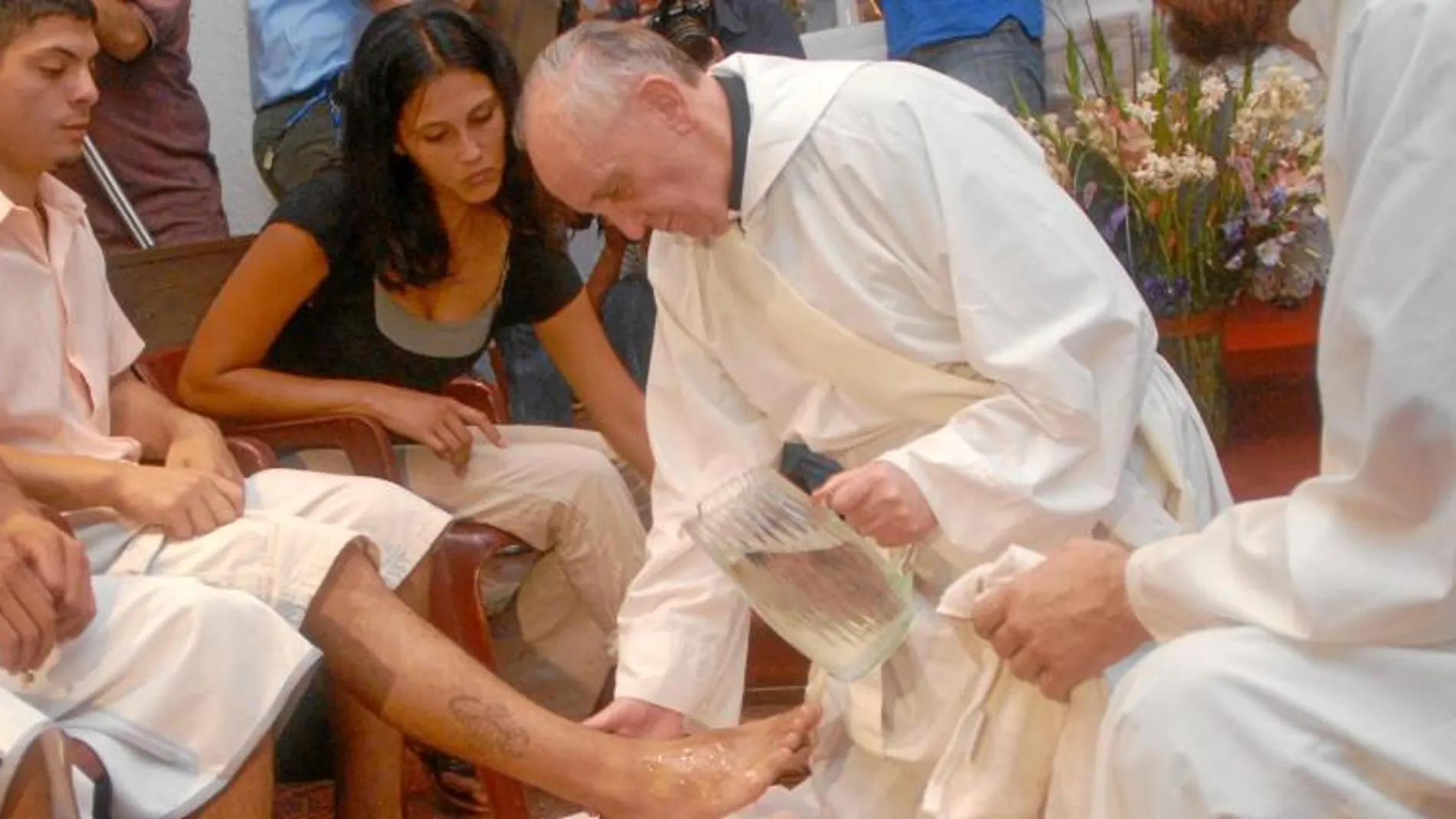 El que fuera cardenal Bergoglio, en Villamiseria (Buenos Aires), durante el lavatorio de los pies con unos jóvenes