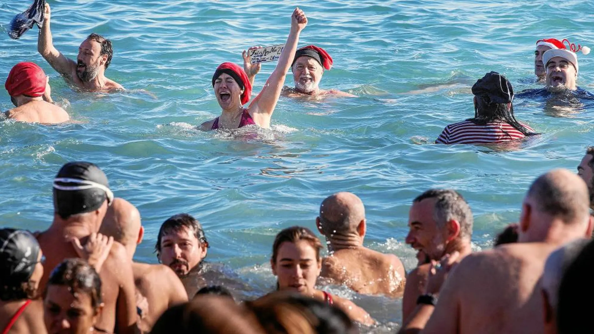 Cientos de personas participan en el tradicional primer baño de mar del año.