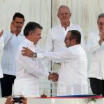 El presidente de Colombia, Juan Manuel Santos y el jefe de las FARC, Rodrigo Londono, alias Timochenko, se saludan tras la firma del acuerdo de paz