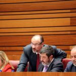 El portavoz de Ciudadanos, Luis Fuentes, conversa con el procurador Manuel Mitadiel, durante una sesión plenaria en las Cortes, en presencia de sus compañeros de grupo, David Castaño y Belén Rosado