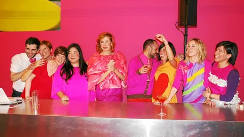 Ágatha –en la imagen con amigos y clientes–, tiene expuesto un vestido con la bandera de España en su tienda de Serrano