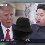 Un hombre observa una pantalla de televisión que muestra al Trump y a Kim Jong Un