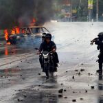 Un policía antidisturbios apunta a dos hombres durante las protestas contra el gobierno del presidente Daniel Ortega en Managua, Nicaragua / Reuters