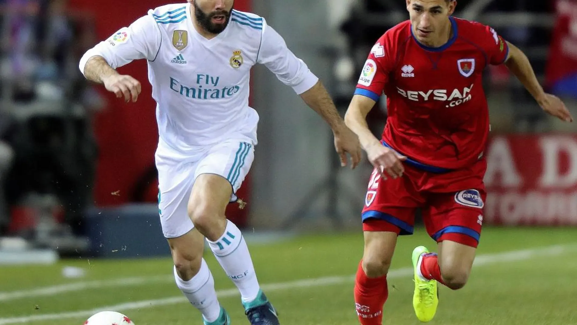El defensa del Real Madrid Dani Carvajal (i) pelea un balón con el centrocampista del Numancia Pere Milla en partido de ida de octavos de final de la Copa del Rey
