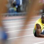 Bolt, por los suelos después de lesionarse, mira desesperado cómo continúa la carrera de 4x100