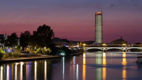 Vista nocturna del rascacielos, justo detrás del puente de Triana