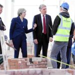 La primera ministra británica, Theresa May, y el ministro de Economía, Philip Hammond, visitan las obras del Leeds College of Building, ayer