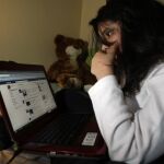 Una joven consulta su perfil de Facebook