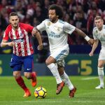 El lateral brasileño del Real Madrid Marcelo (d) escapa de Koke, del Atlético de Madrid