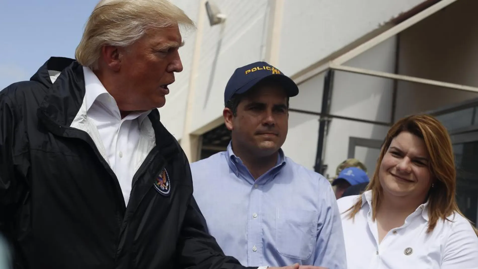 El presidente de Estados Unidos, Donald Trump (i), habla junto a la comisionada de Puerto Rico residente en Washington, Jenniffer González (d), y el gobernador de Puerto Rico, Ricardo Rosselló (c), a su llegada al municipio de Guaynabo