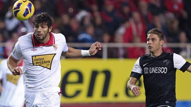 El defensa argentino del Sevilla CF, Federico Fazio (i), recupera un balón ante Joaquín Sánchez, del Málaga CF
