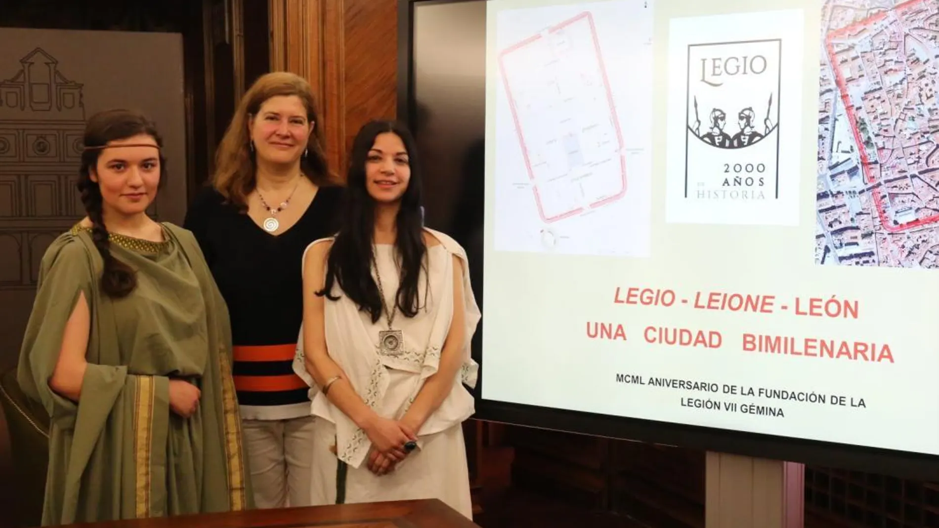 La concejal Margarita Torres presenta el programa de actividades junto a dos jóvenes ataviadas con vestimenta romana