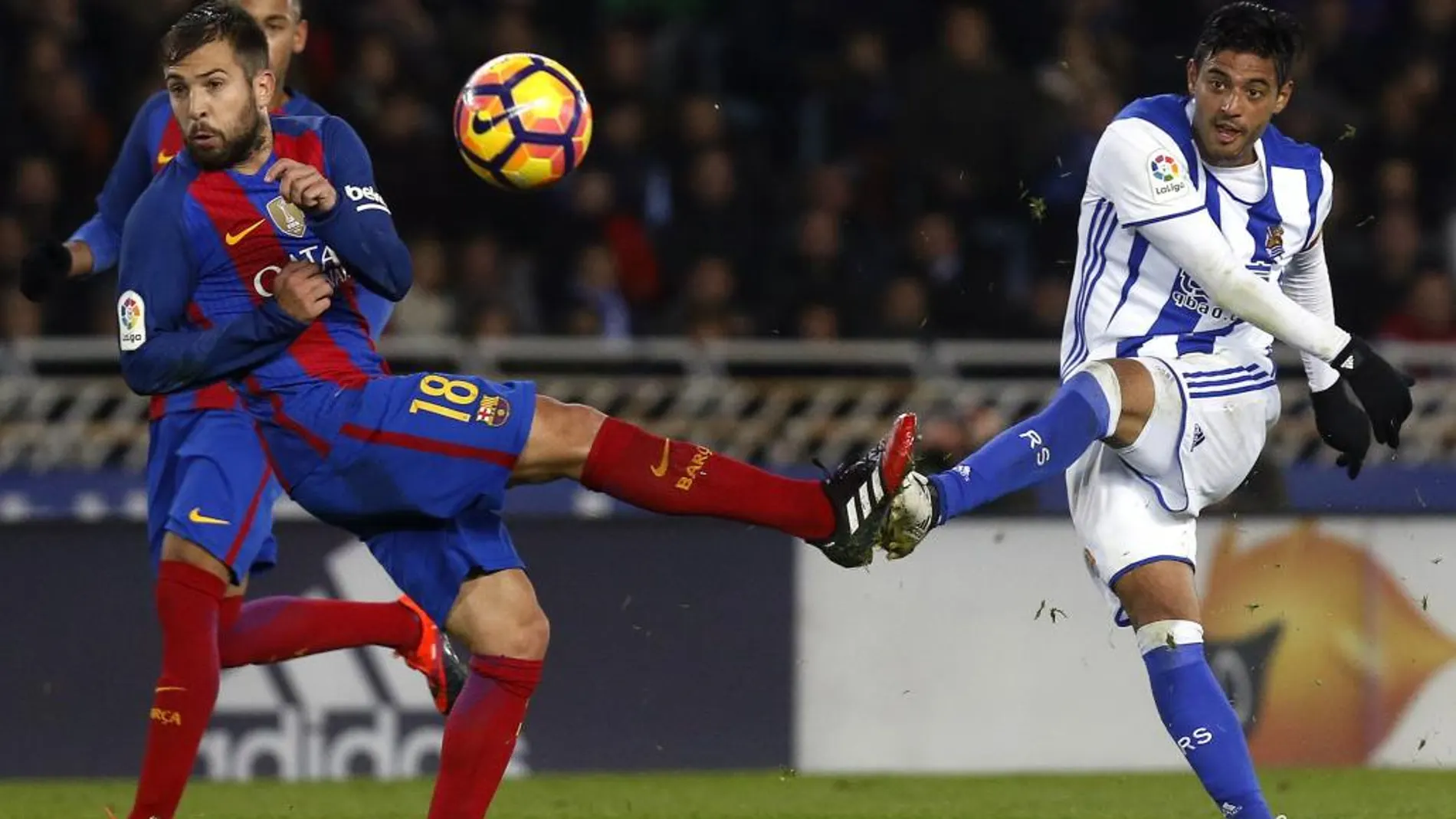 Carlos Vela (d), golpea el balón ante el defensa del F. C. Barcelona, Jordi Alba