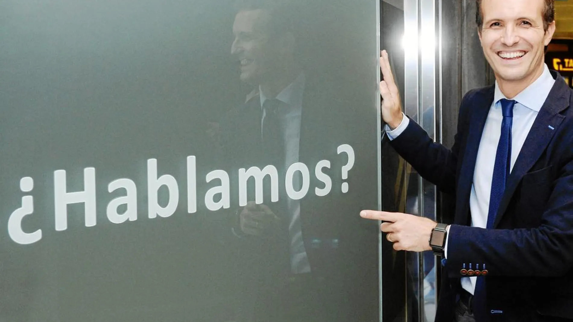 El candidato a la presidencia del Partido Popular, Pablo Casado, posa ayer junto a una publicidad de un establecimiento comercial tras el encuentro con compromisarios en Valladolid