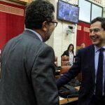 El presidente del Gobierno andaluz, Juanma Moreno, saludó ayer antes del Pleno al portavoz parlamentario de Vox, Francisco Serrano / Foto: Manuel Olmedo