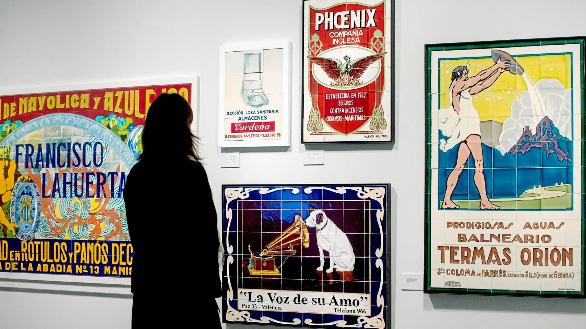 Una mujer contempla las piezas de cerámica de la exposición