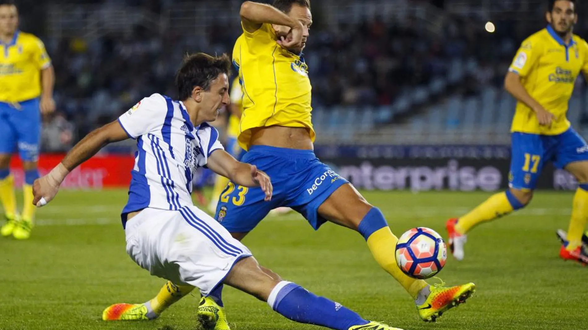 El delantero de la Real Sociedad, Mikel Oyarzabal (i), golpea el balón ante el defensa de la UD Las Palmas