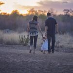 Unos padres pasean con su hija por el campo