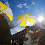 Un grupo de monjas indican con sus paraguas el lugar dónde se daba la comunión en una misa en la Plaza Mayor de Madrid