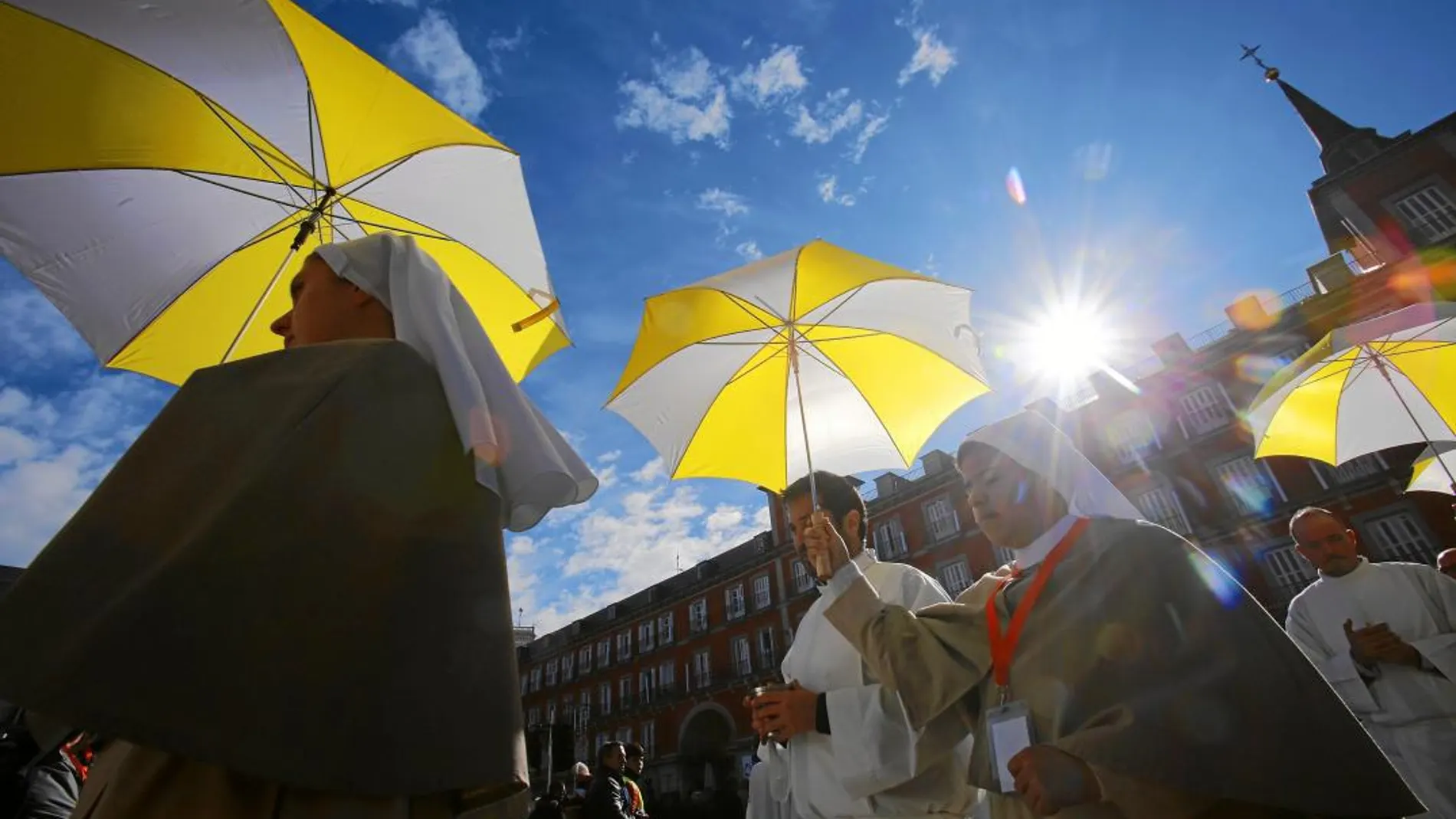 Un grupo de monjas indican con sus paraguas el lugar dónde se daba la comunión en una misa en la Plaza Mayor de Madrid