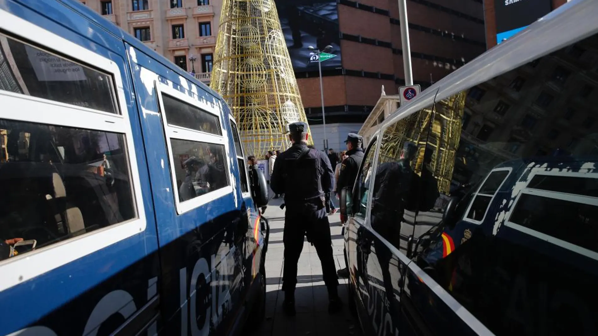 Agentes y vehículos de la policía vigilan en la plaza del Callao de Madrid