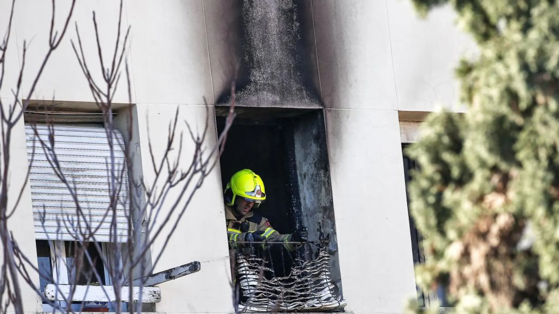 Un bombero inspecciona la vivienda calcinada en la avenida de Aragón, de Valencia