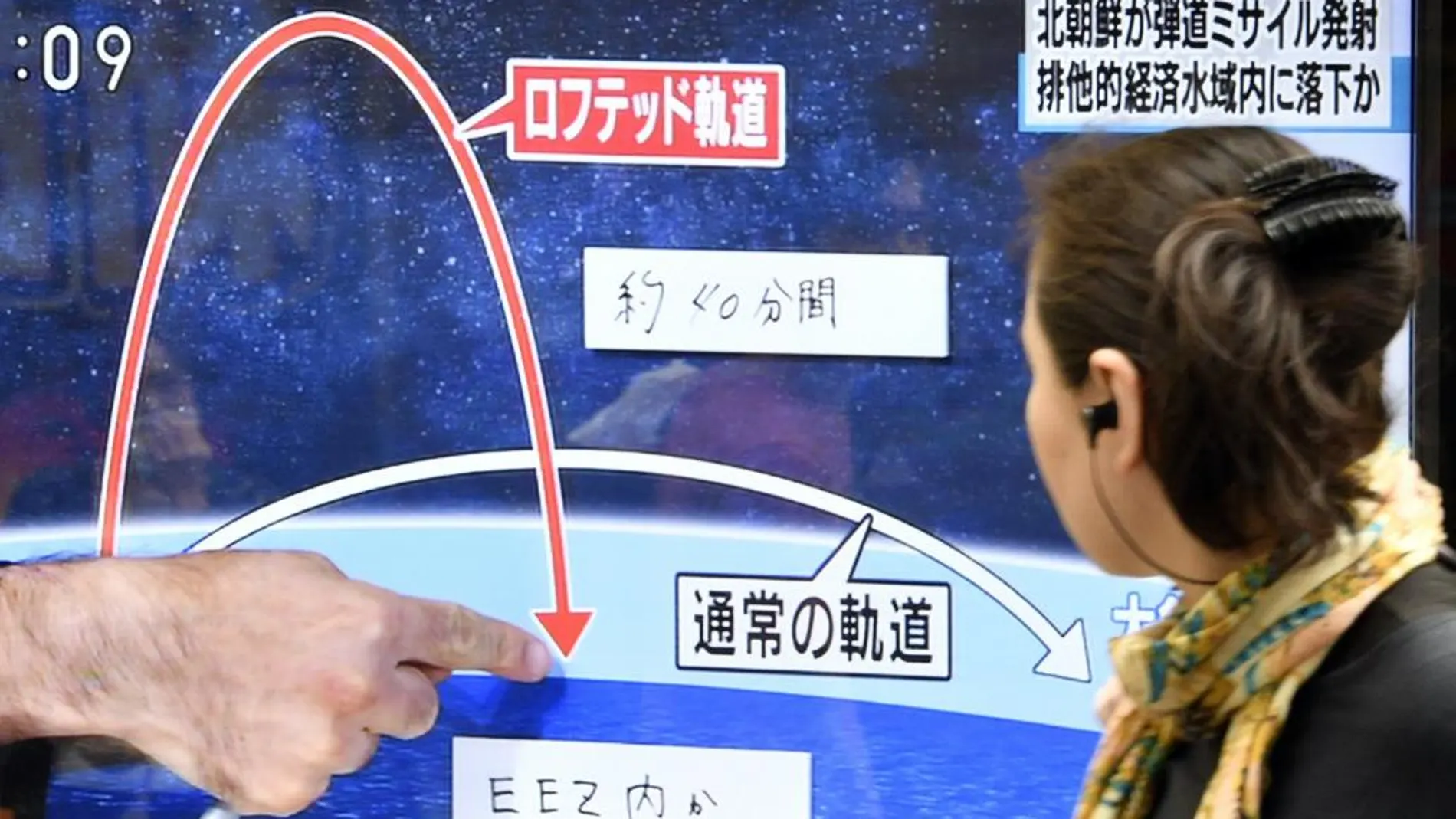 Una persona observa una pantalla de televisión, en Tokio (Japón) mientras un telediario informa sobre el lanzamiento de un misil de Corea del Norte, en el mar japonés