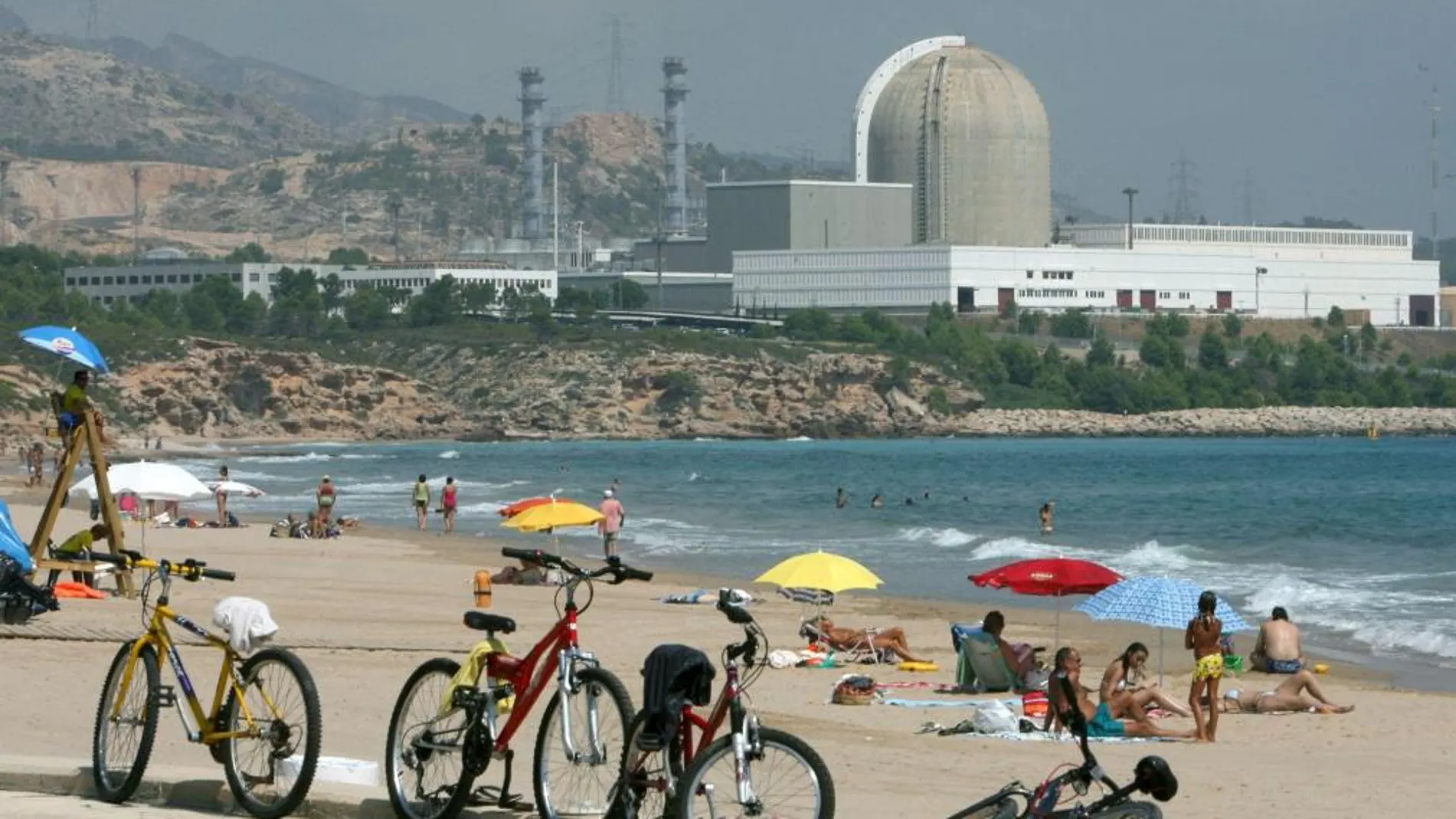 Unos bañistas frente a la central nuclear de Vandellós