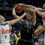 El pívot de Iberostar Tenerife, Fran Vázquez (c), disputa el balón con los jugadores del Real Madrid, Felipe Reyes (i) y Jonas Maciulis (d).