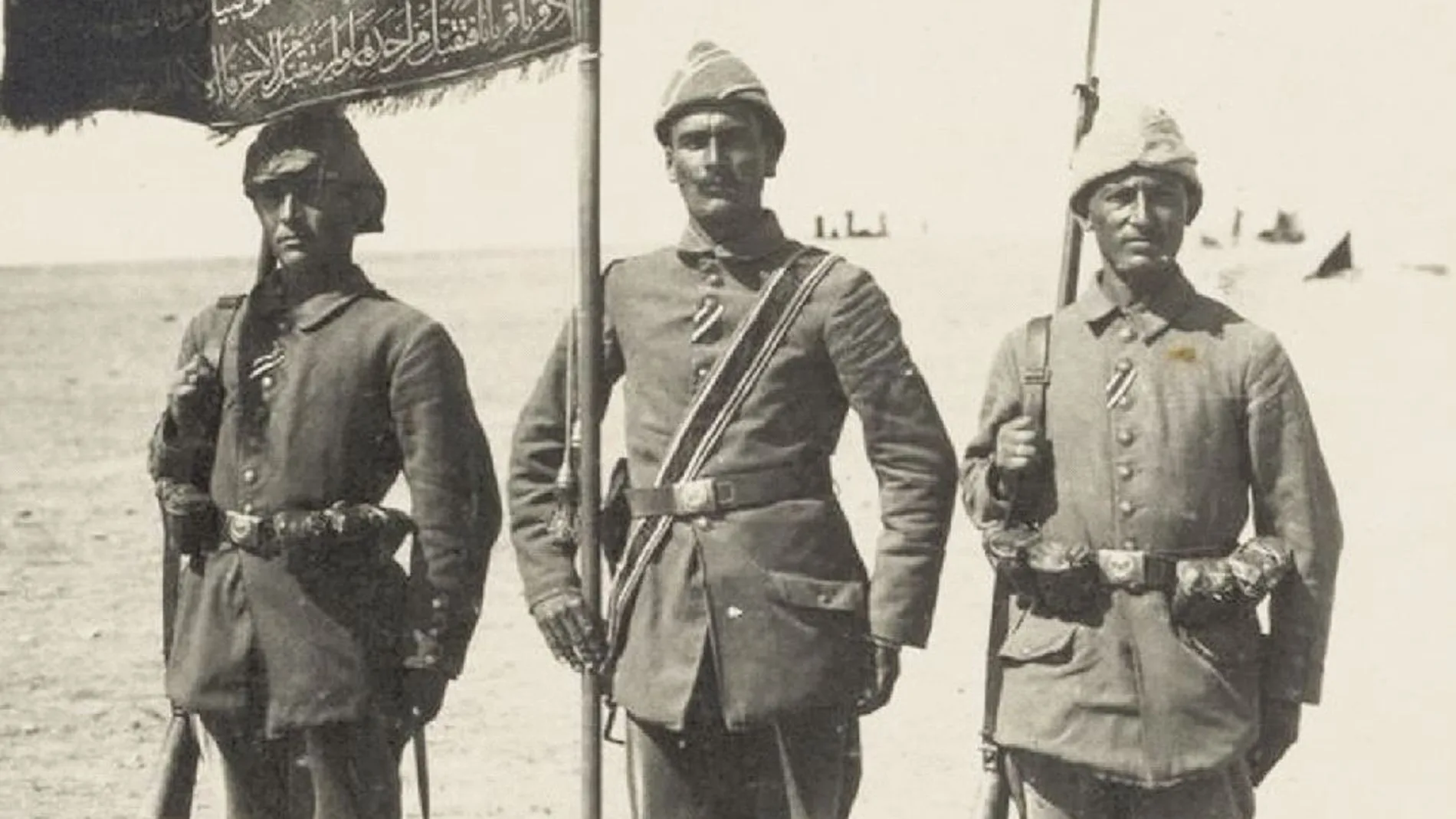 Tres soldados turcos con sus uniformes y con las banderas de su regimiento. Para Turquía no hubo paz tras 1918