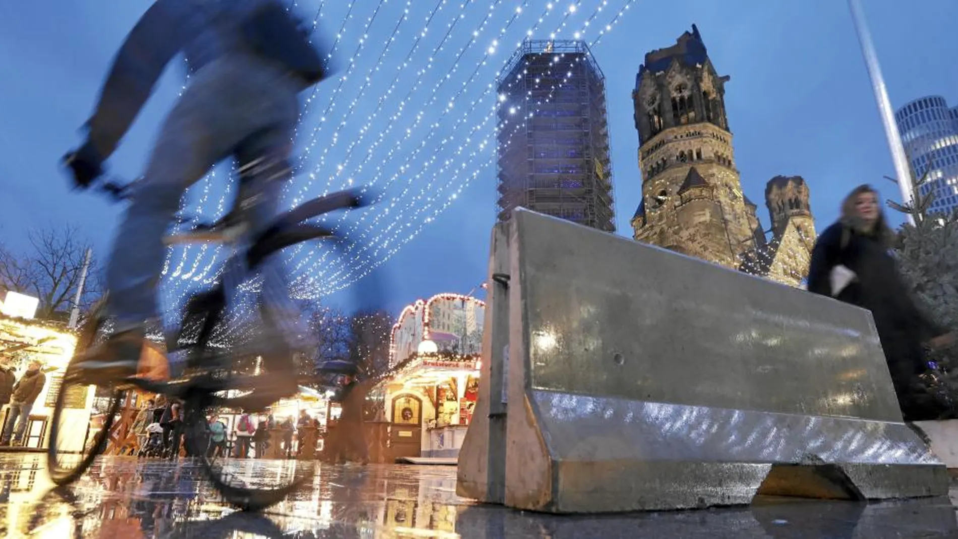 Un ciclista pasa junto a uno de los bloques de hormigón que protegen el mercadillo navideño de Breitscheidplatz, donde el pasado 19 de diciembre un yihadista mató a 12 personas en un atropello múltiple