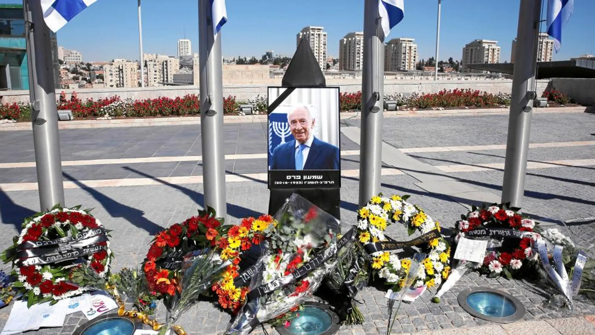 Coronas de flores junto a un retrato de Simon Peres en la plaza del Parlamento de Israel, ayer, en la ciudad de Jerusalén