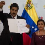 El gobernante encargado y candidato del oficialismo, Nicolás Maduro, saluda tras ser proclamado como presidente de Venezuela ante el Consejo Nacional Electoral junto a la directora del orgaismo, Tibisay Lucena